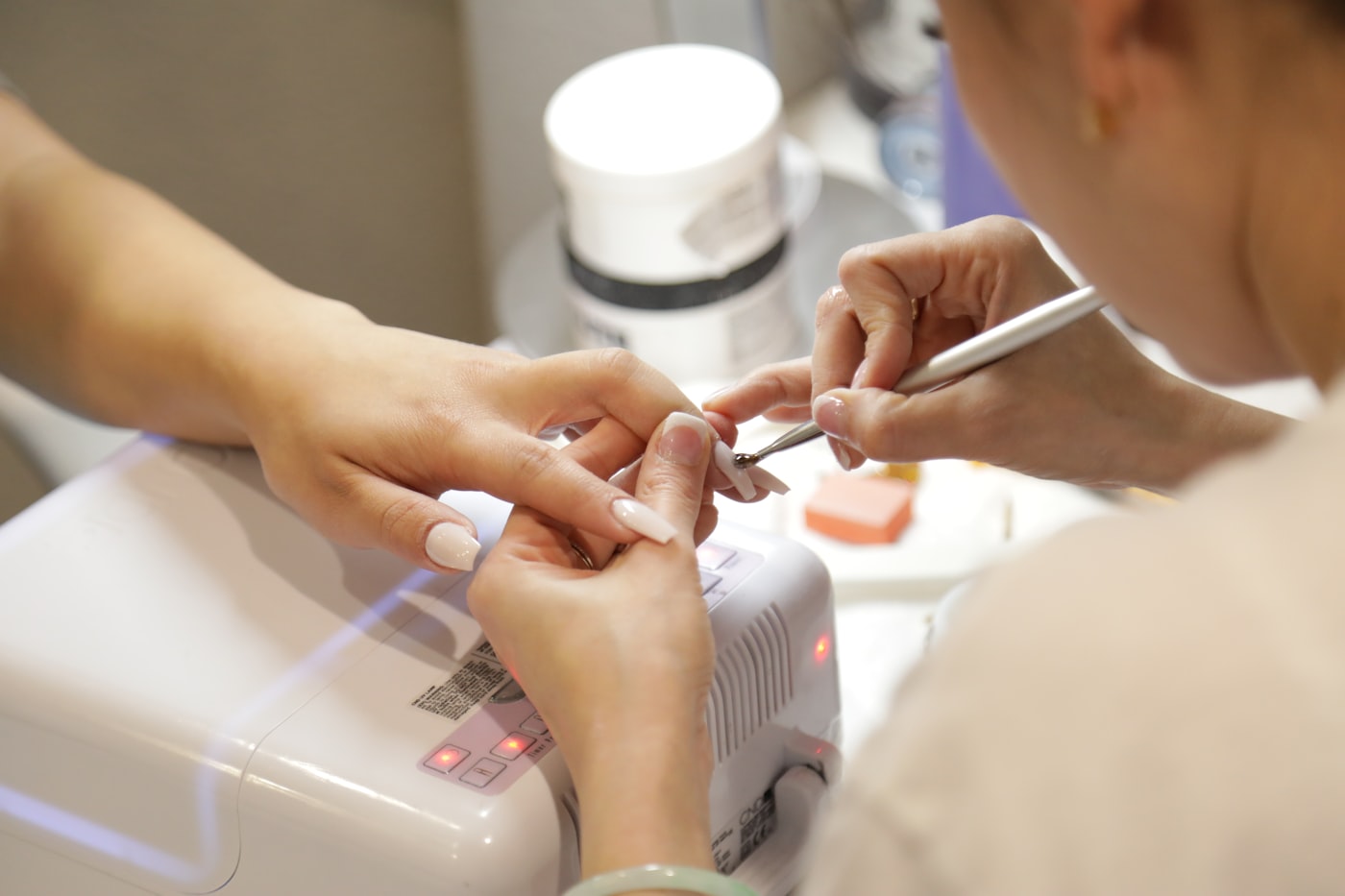 A nail technician performing a detailed manicure